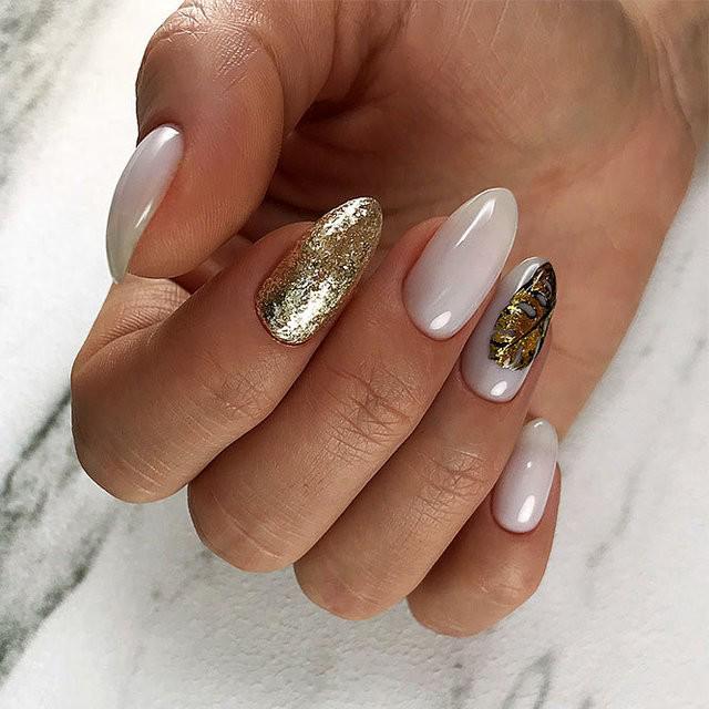 รูปภาพ:http://glaminati.com/wp-content/uploads/2018/03/almond-shaped-nails-white-gold-glitter-long-leave-design.jpg