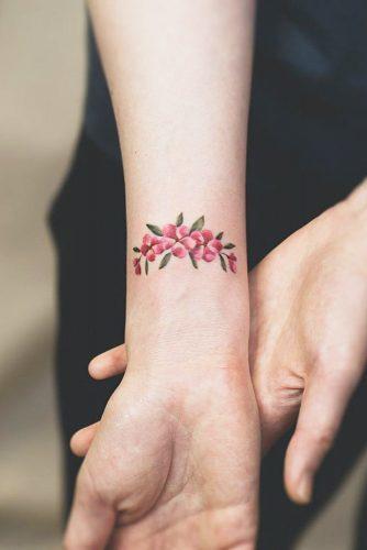 รูปภาพ:http://glaminati.com/wp-content/uploads/2018/06/delicate-wrist-tattoos-pink-flowers-leaves-334x500.jpg