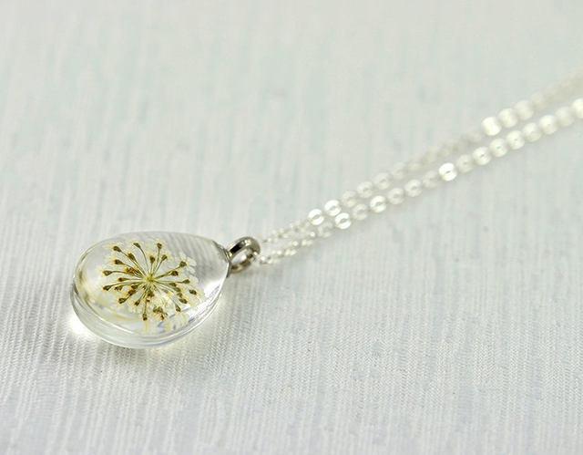 รูปภาพ:https://www.invoguejewellery.com.au/wp-content/uploads/2018/05/white-real-flower-teardrop-necklace-white-dried-flower-necklace-pressed-flower-silver-drop-necklace-terrarium-glass-necklace-jewellery-5afa5523.jpg