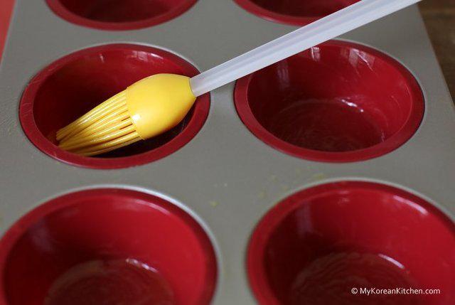 รูปภาพ:http://koreankitchen.wpengine.netdna-cdn.com/wp-content/uploads/2013/11/Step-2.-Brush-some-melted-butter-on-the-individual-muffin-holes-of-the-tray.jpg