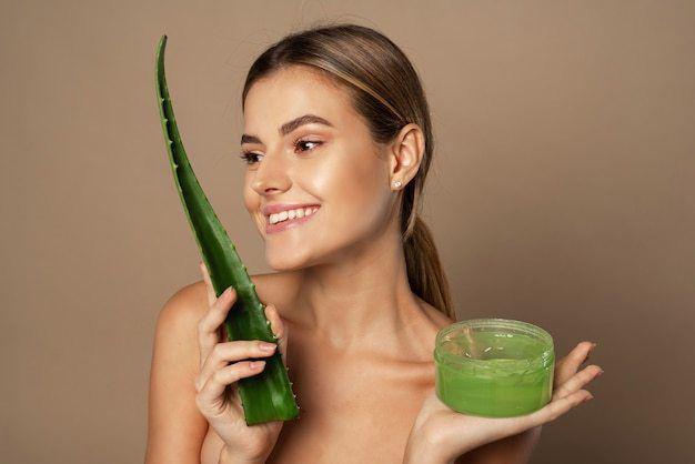 รูปภาพ:https://img.freepik.com/free-photo/smiling-happy-young-female-model-holding-aloe-leaf-jar-aloe-gel-beige-background-concept-skin-care-moisturizing-with-natural-cosmetics_121946-2683.jpg