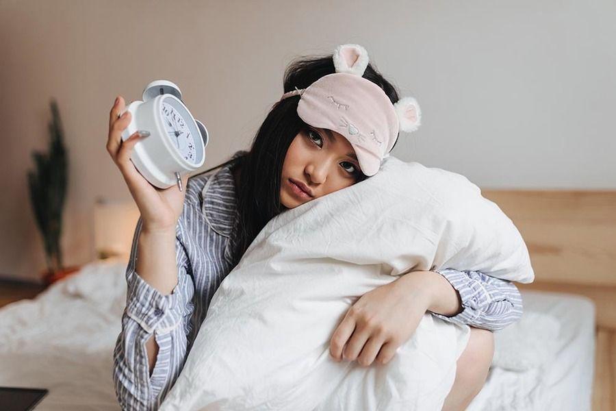 รูปภาพ:https://invivo-environnement.com/wp-content/uploads/2023/02/sad-girl-pajamas-sleep-mask-is-hugging-white-pillow-holding-alarm-clock.jpg
